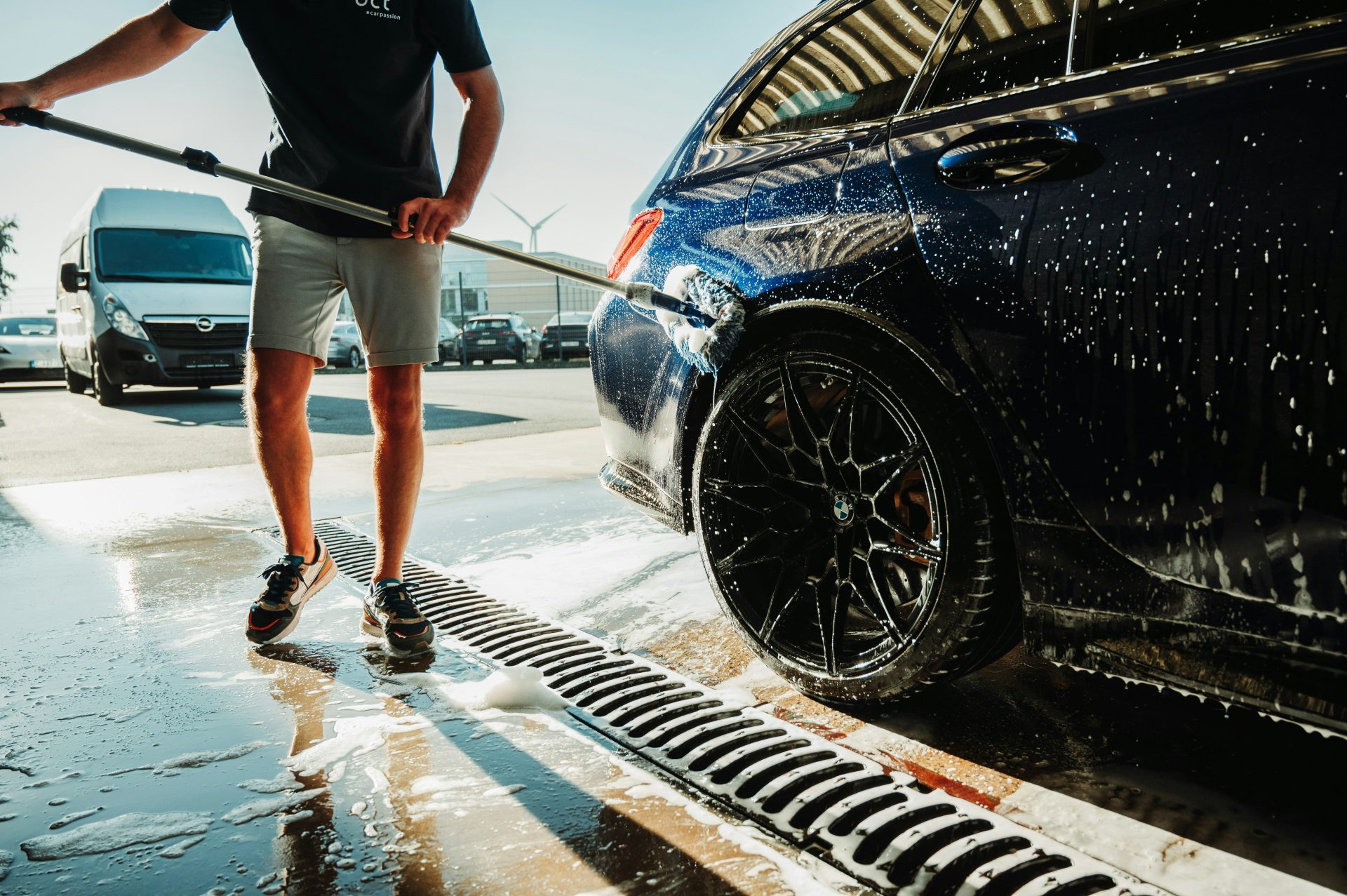 a man is washing a car with a hose